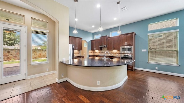 322 Wauford Way, New Braunfels, TX 78132 - kitchen featuring appliances with stainless steel finishes, a sink, dark wood finished floors, decorative backsplash, and decorative light fixtures