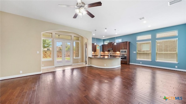 322 Wauford Way, New Braunfels, TX 78132 - unfurnished living room with arched walkways, dark wood finished floors, healthy amount of natural light, ceiling fan, and recessed lighting