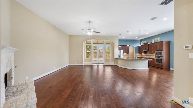 322 Wauford Way, New Braunfels, TX 78132 - unfurnished living room featuring a ceiling fan, arched walkways, a fireplace, dark wood-type flooring, and recessed lighting