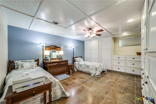 bedroom featuring tile patterned floors, visible vents, and ceiling fan