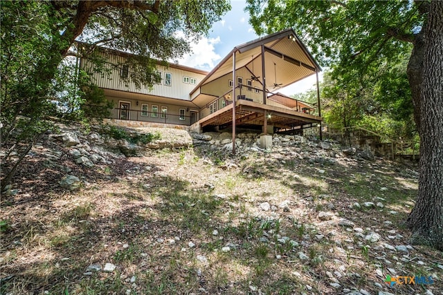 back of property with a deck and a ceiling fan