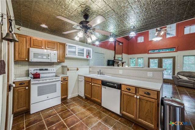 kitchen with white appliances, hanging light fixtures, sink, kitchen peninsula, and ceiling fan