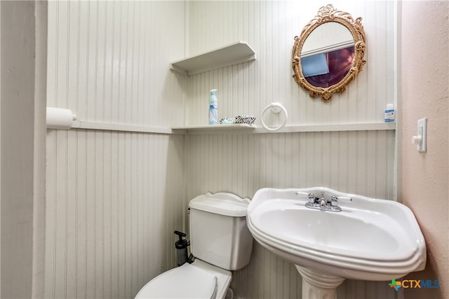 half bath featuring toilet and a sink