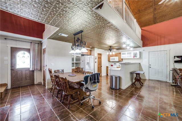 dining area featuring wood walls and ceiling fan