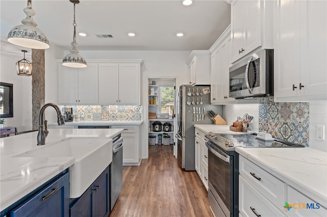 kitchen featuring blue cabinets, appliances with stainless steel finishes, hardwood / wood-style flooring, and white cabinets