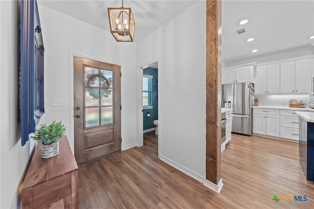 foyer entrance featuring a chandelier and light wood-type flooring