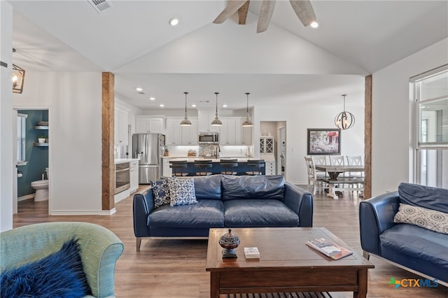 living room featuring sink, ceiling fan, beam ceiling, high vaulted ceiling, and wood-type flooring