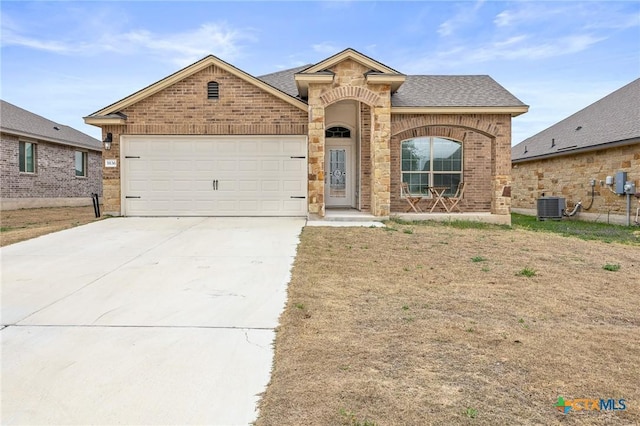 view of front of property with central AC unit and a garage