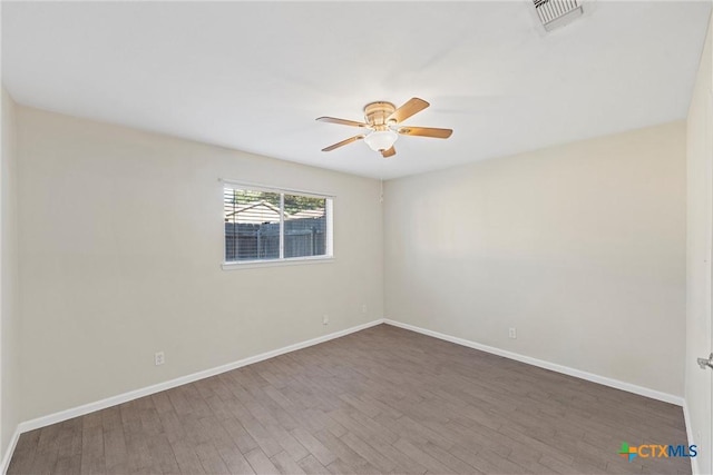 spare room featuring ceiling fan and dark hardwood / wood-style floors