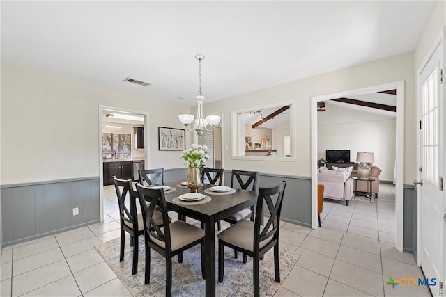 dining space with light tile patterned flooring, vaulted ceiling with beams, and a notable chandelier