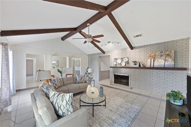 living room with lofted ceiling with beams, brick wall, light tile patterned floors, a brick fireplace, and ceiling fan