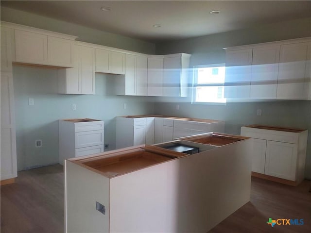 kitchen featuring a center island, white cabinets, recessed lighting, and wood finished floors