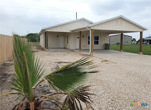 view of front of home with an attached carport, fence, and board and batten siding