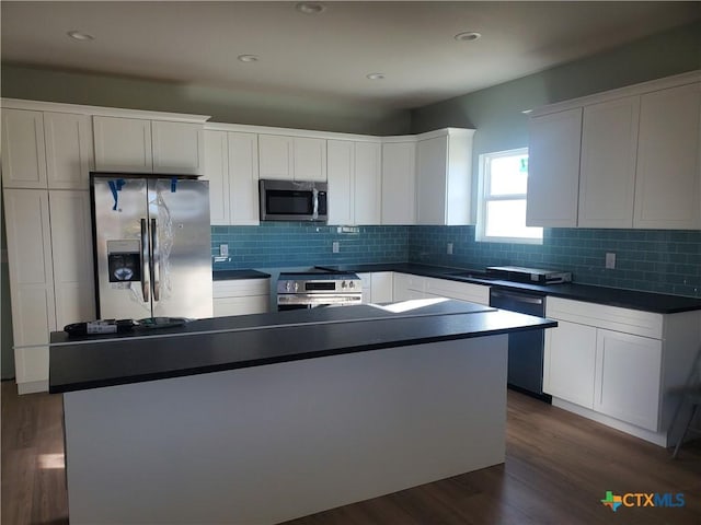 kitchen with stainless steel appliances, dark wood-type flooring, dark countertops, and decorative backsplash