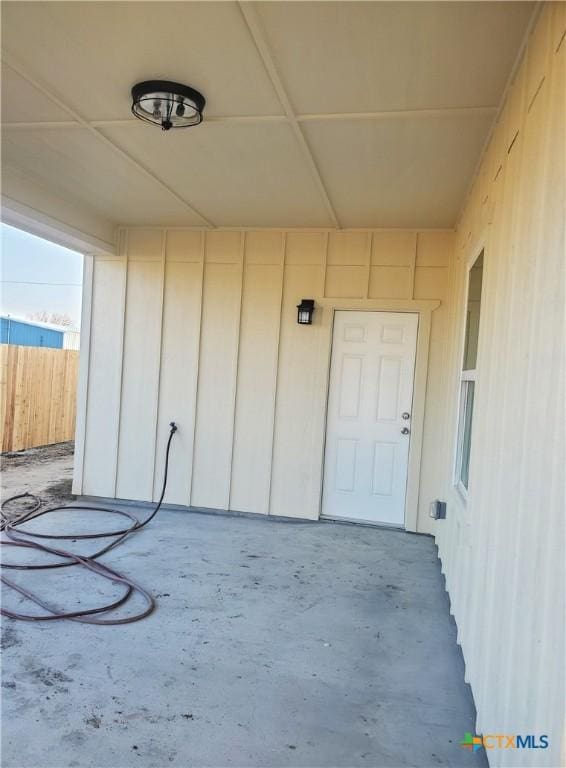 entrance to property with fence and board and batten siding