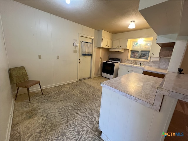 kitchen featuring white stove, kitchen peninsula, a textured ceiling, sink, and white cabinetry