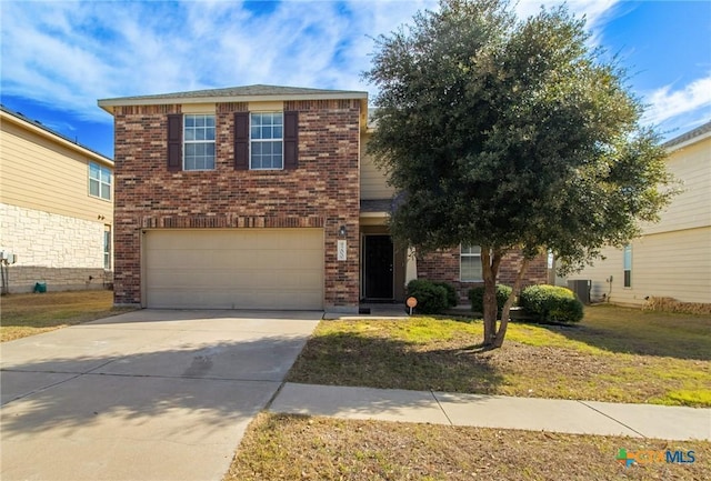 traditional home featuring concrete driveway, brick siding, and a front yard