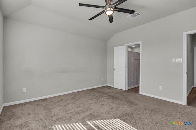 unfurnished bedroom with dark colored carpet, vaulted ceiling, and ceiling fan