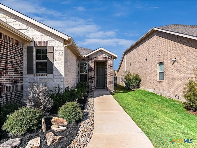 entrance to property with a lawn