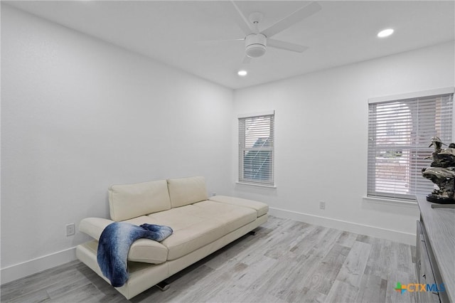 living area with recessed lighting, light wood-style flooring, a ceiling fan, and baseboards