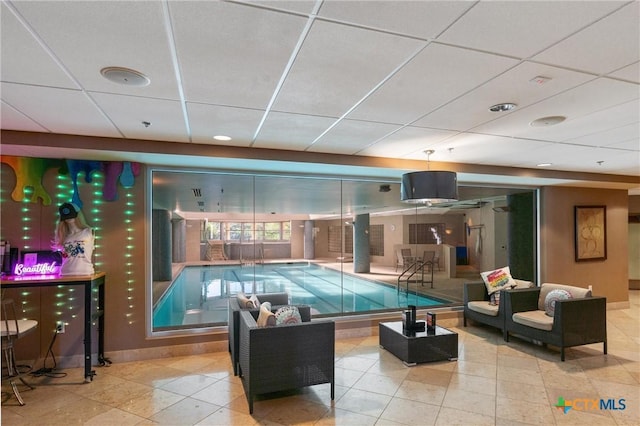 playroom featuring baseboards, tile patterned flooring, and a paneled ceiling