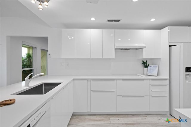 kitchen featuring visible vents, white appliances, modern cabinets, and a sink
