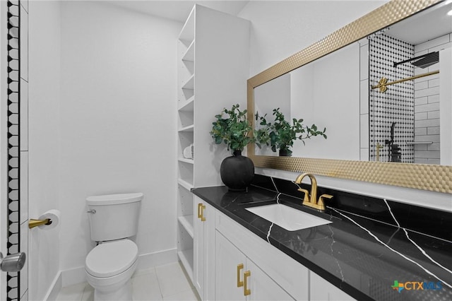 bathroom with vanity, toilet, a shower, baseboards, and tile patterned flooring