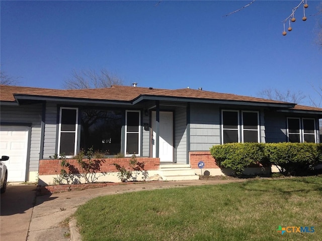 ranch-style house with a garage and a front lawn