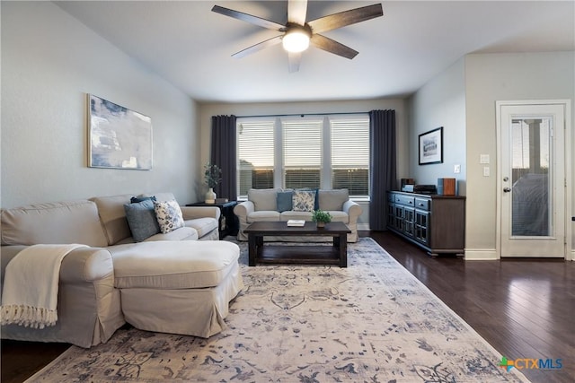 living room with dark wood-type flooring and ceiling fan