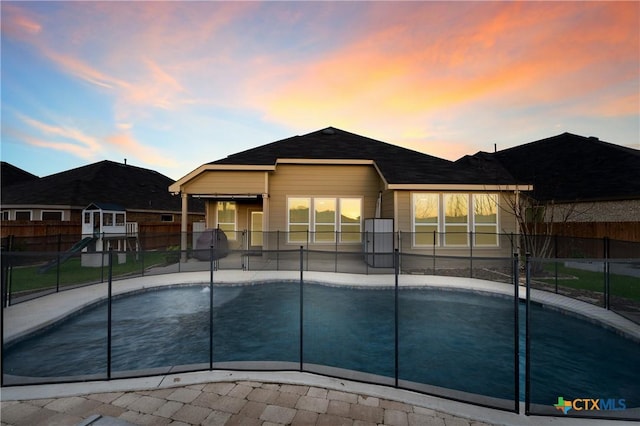 pool at dusk with a patio area