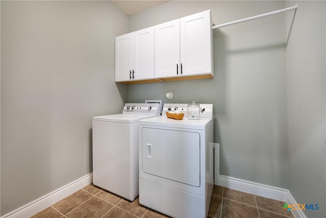 laundry room featuring cabinets, washer and dryer, and dark tile patterned flooring