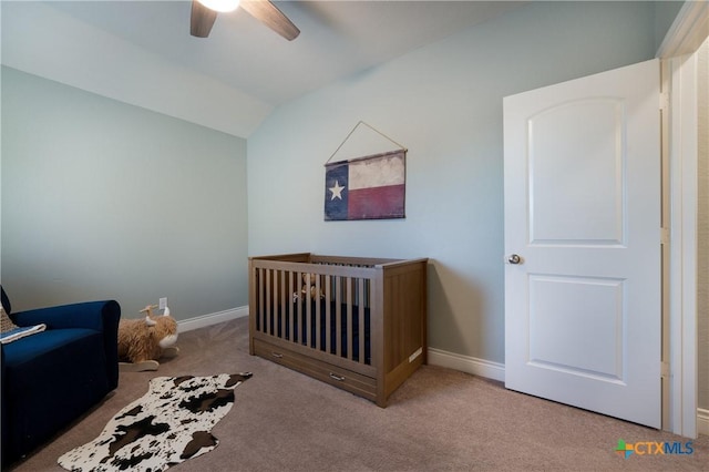 unfurnished bedroom featuring a nursery area, ceiling fan, lofted ceiling, and carpet