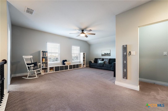 living area with vaulted ceiling, ceiling fan, and carpet flooring