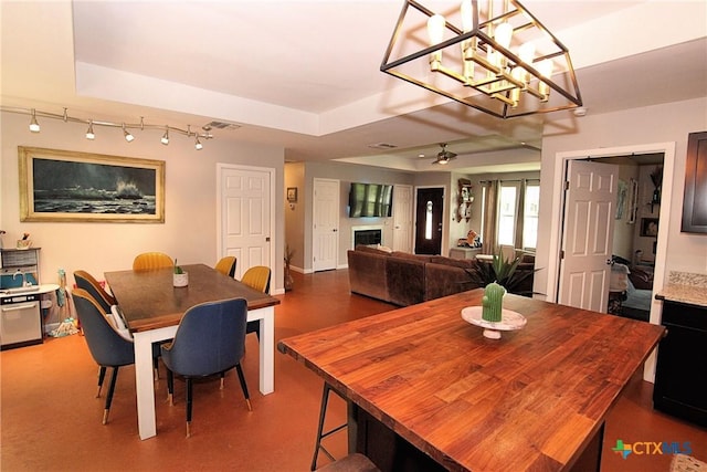 dining room with ceiling fan and a raised ceiling