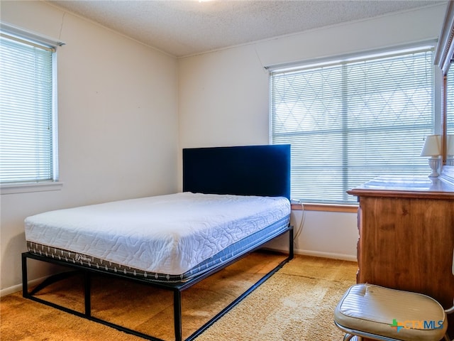 carpeted bedroom featuring multiple windows and a textured ceiling