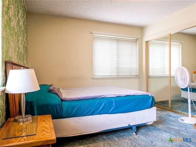 carpeted bedroom featuring a closet and a textured ceiling