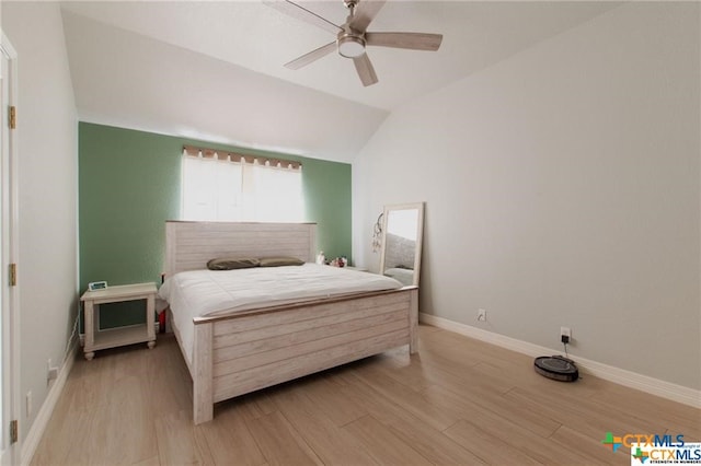 bedroom featuring light hardwood / wood-style flooring, ceiling fan, and vaulted ceiling