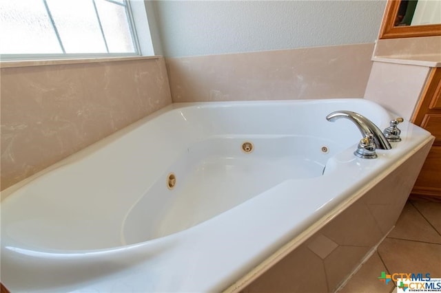 bathroom with tile patterned flooring and a washtub