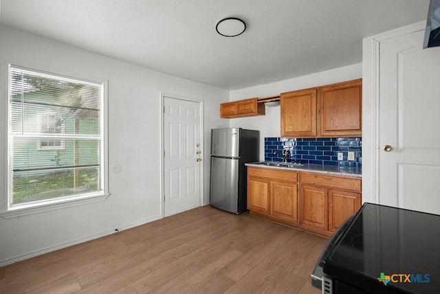 1404 Mulford St, Killeen, TX 76541 - kitchen with freestanding refrigerator, black range with electric stovetop, healthy amount of natural light, and brown cabinetry