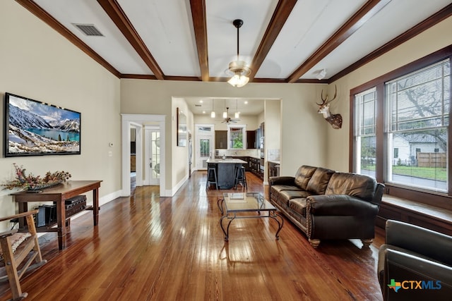 living room featuring ornamental molding, beamed ceiling, dark hardwood / wood-style floors, and ceiling fan