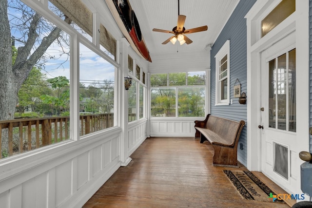 sunroom with a water view and ceiling fan