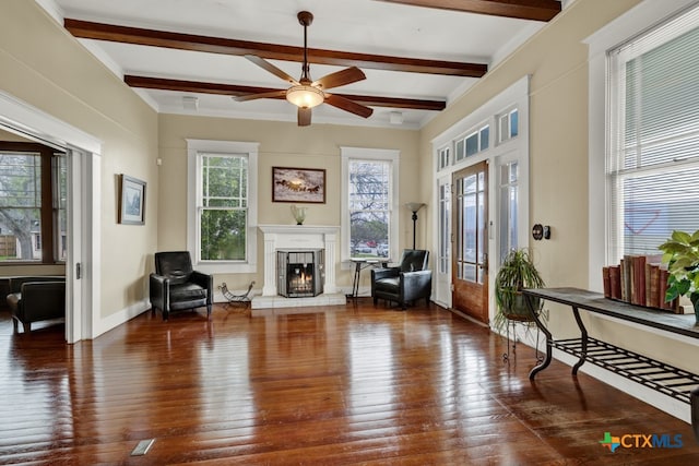 living area featuring dark hardwood / wood-style flooring, beamed ceiling, and ceiling fan