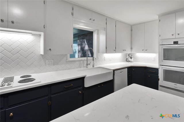 107 Spokane St, Victoria, TX 77904 - kitchen featuring white appliances, a sink, tasteful backsplash, and dark cabinetry