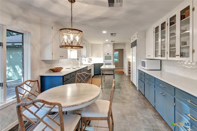 107 Spokane St, Victoria, TX 77904 - kitchen featuring blue cabinetry, white appliances, a sink, tasteful backsplash, and white cabinetry