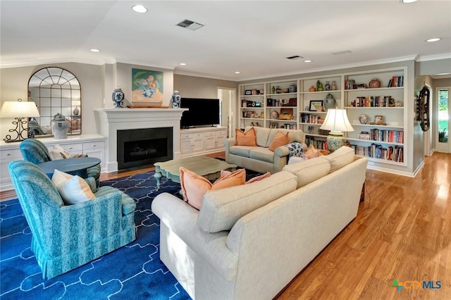 107 Spokane St, Victoria, TX 77904 - living room featuring wood finished floors, crown molding, a fireplace with flush hearth, and recessed lighting