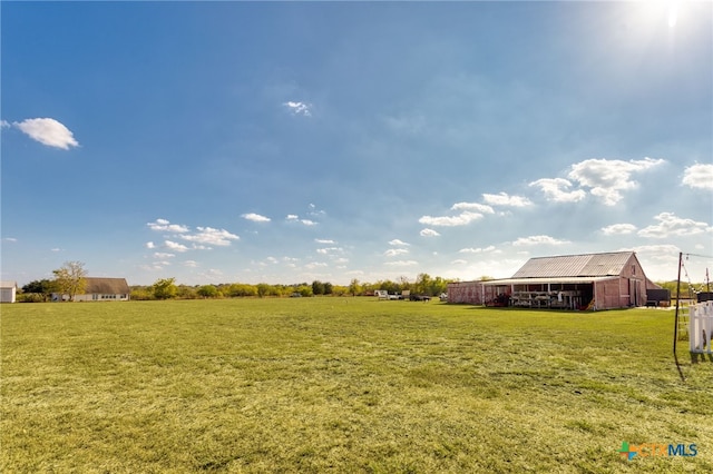 view of yard with an outbuilding and a rural view