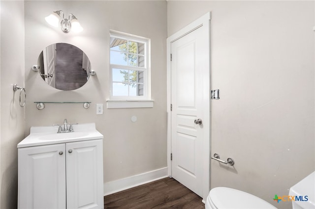 bathroom featuring toilet, vanity, and hardwood / wood-style flooring