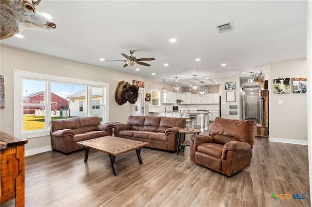 living room with wood-type flooring and ceiling fan