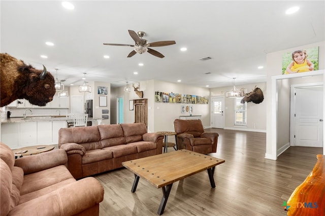 living room featuring ceiling fan and light hardwood / wood-style flooring