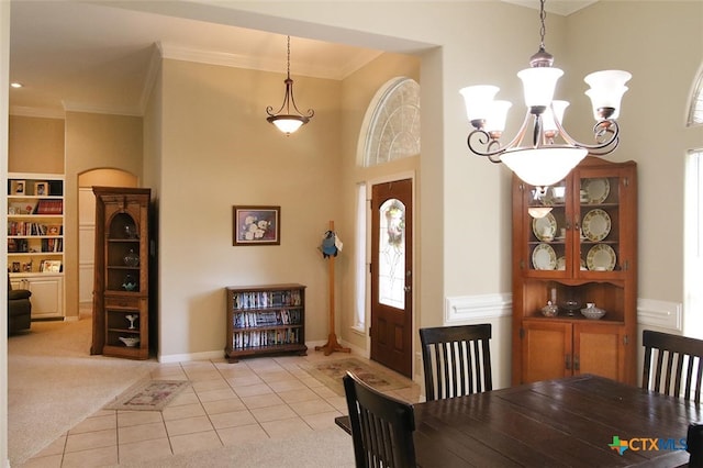 dining area featuring ornamental molding, light carpet, and an inviting chandelier